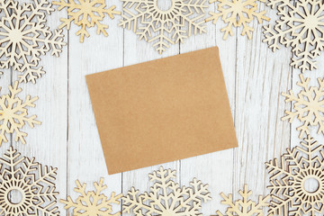 Wall Mural - Brown greeting card with wood snowflakes on weathered whitewash textured wood background