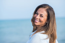 Beautiful Middle Age Hispanic Woman Standing With Smile On Face At The Ocean. Smiling Confident And Cheerful On A Sunny Day With Sea View. .