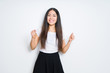 © Krakenimages.com - Beautiful brunette woman over isolated background very happy and excited doing winner gesture with arms raised, smiling and screaming for success. Celebration concept.