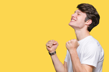 Young handsome man wearing casual white t-shirt over isolated background celebrating surprised and amazed for success with arms raised and open eyes. Winner concept.