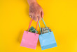 female hand hold little shopping bags with australian and  United States dollar money
