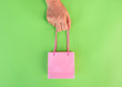 female hand hold empty little shopping bag