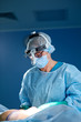 © Georgii - Close up portrait of female surgeon doctor wearing protective mask and hat during the operation. Healthcare, medical education, surgery concept.