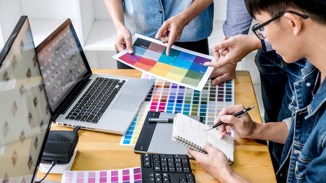 Team of young colleagues creative graphic designer working on color selection and drawing on graphics tablet at workplace, Color swatch samples chart for selection coloring