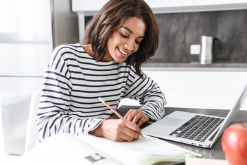 Sticker - Attractive young african woman using laptop computer