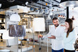 © JackF - Smiling couple customers choosing floor lamp with a long standard in store
