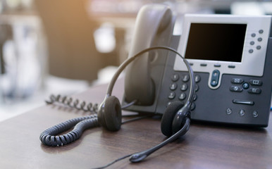 Wall Mural - close up soft focus on headset with telephone devices at office desk for customer service support concept	