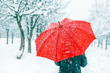 Woman with red umbrella in snow