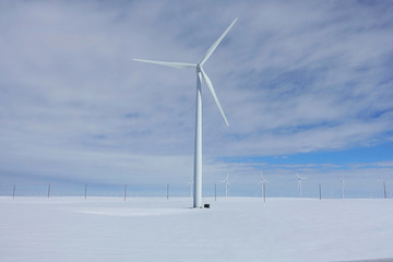 White wind turbine in a field of snow in rural Oregon