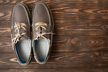 man in brown shoes standing on the wooden background