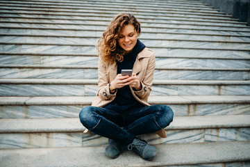 Wall Mural - Female smiling and typing text messages