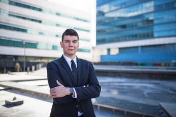 Young and confident politician standing in front of a building