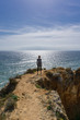 © grenierb - Woman hikes ocean ridge to horizon in Portugal