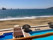 Blick über den Strand mit Pool und den Pazifischen Ocean in Manzanillo in Mexico die Schiffe warten auf die Fahrt in den Hafen