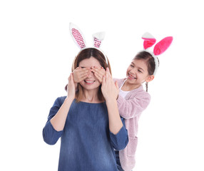 Wall Mural - Happy woman and daughter with bunny ears on white background