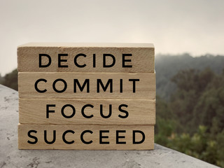 Wall Mural - Motivational and inspirational words - Decide, Commit, Focus,Succeed written on wooden rectangular blocks.