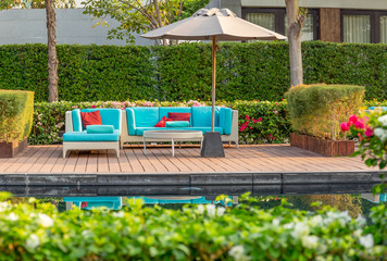 Wall Mural - Large terrace patio with rattan furniture in the garden with umbrella.