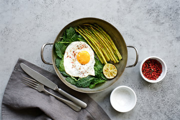 Wall Mural - Fried egg with kale and asparagus. Healthy and nutritious food concept