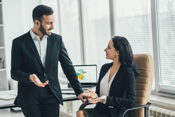 Wall Mural - The happy business man and a woman talking near the office table