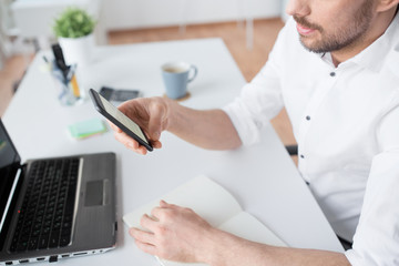 Wall Mural - business, communication and technology concept - close up of businessman using smartphone at office