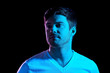 © Syda Productions - people concept - portrait of young man in t-shirt over ultra violet neon lights in dark room