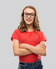 Canvas Print - education, school and people concept - smiling teenage student girl in glasses and red t-shirt with crossed arms over grey background