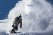 Male Snowboarder Curved And Brakes Spraying Loose Deep Snow On The Freeride Slope