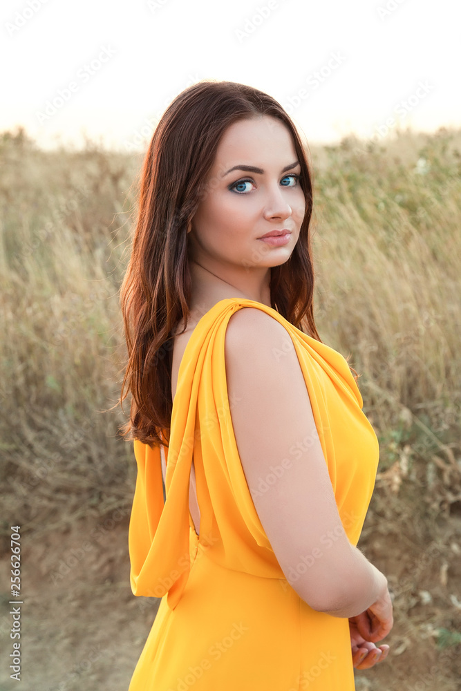 yellow dress brown hair Beautiful Brunette In Yellow Dress Relaxing On Beach Stock Photo - Download Image Now