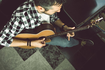 Young man playing classical guitar in studio. Musician guitarist