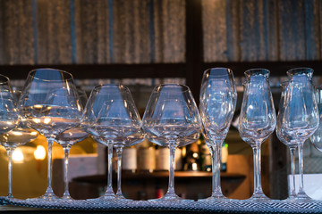 Transparent alcohol drink glasses on shelf at the bar