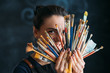 © golubovy - Artist and art supplies. Tools for talent. Smiling woman painter in apron posing with paintbrushes bunch.