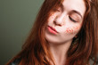© golubovy - Young woman portrait. Skeptical facial expression. Redhead female with pursed pout lips looking sideways.
