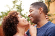 Happy middle aged black couple embracing outdoors, side view,close up