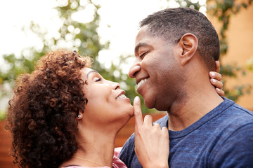 Happy middle aged black couple embracing outdoors, side view,close up