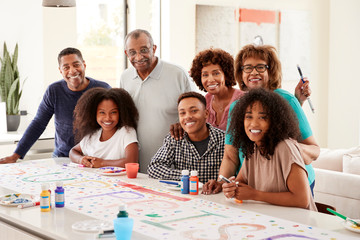 Wall Mural - Three generation black family making a sign for surprise party smiling to camera,close up