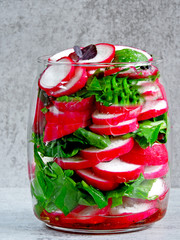 Wall Mural - Radish salad with spinach in a jar. Fitness salad in the jar. Fresh radishes and fresh chopped spinach leaves. Vegetable salad in a jar to go.