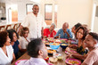 © Monkey Business - Three generation black family sitting at dinner table celebrating together,close up