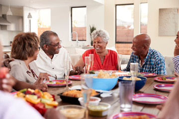 Wall Mural - Grandfather making a toast standing at the dinner table celebrating with his family,close up