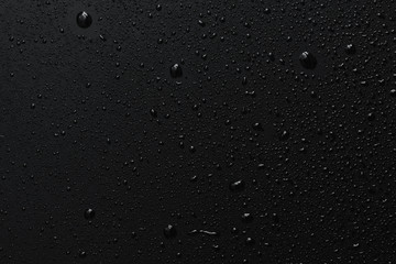 Black surface with clear water drops, background