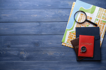 Wall Mural - Map with passports, magnifier and compass on wooden table