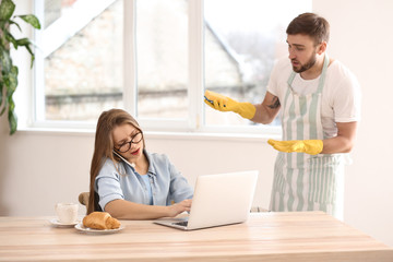 Poster - Busy wife working while her indignant husband doing chores at home