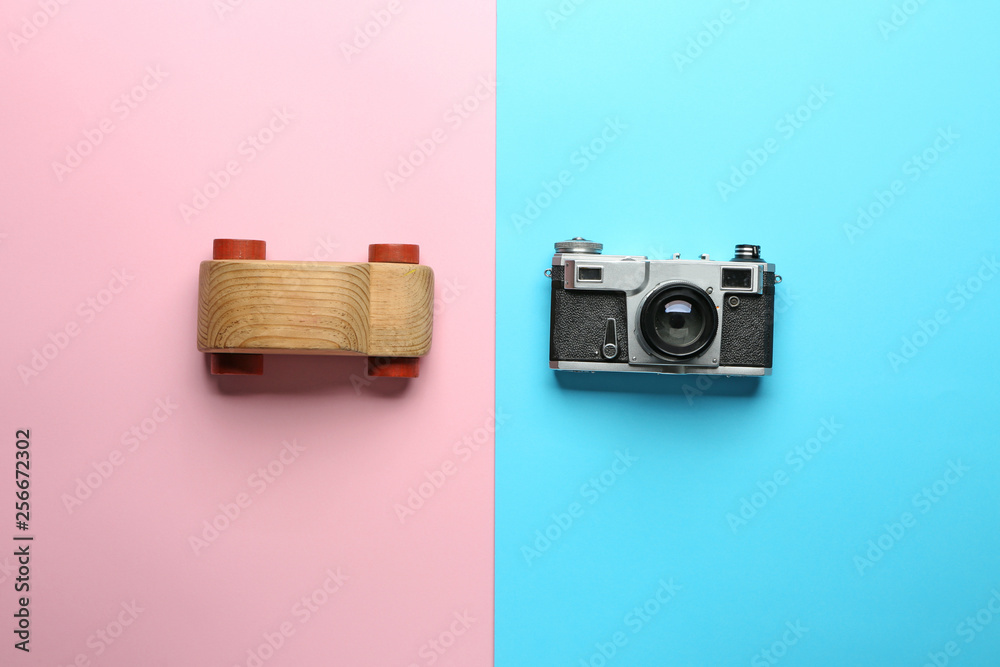 Toy car and photo camera on color background. Travel concept