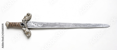 Cuadros en Lienzo Closeup of vintage metal sword decorated with gems on white background