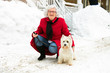 © Louis-Photo - Senior woman Walking Dog Through Snowy street