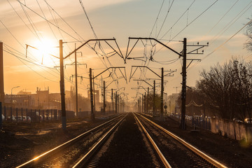 railway rails in the evening in the light of the sun at sunset in early spring