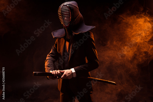 Dekoracja na wymiar  zawodnik-kendo-w-stroju-wizytowym-i-helmie-trzymajacy-bambusowy-miecz-w-ciemnosci
