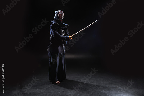 Dekoracja na wymiar  pelny-widok-wojownika-kendo-w-zbroi-cwiczacego-z-bambusowym-mieczem-na-czarno