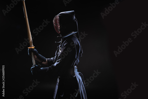 Dekoracja na wymiar  widok-z-boku-wojownika-kendo-w-tradycyjnym-helmie-trzymajacego-bambusowy-miecz-na-czarno