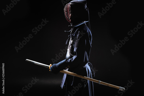 Dekoracja na wymiar  widok-z-boku-wojownika-kendo-w-tradycyjnym-helmie-trzymajacego-bambusowy-miecz-na-czarno