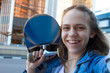 autistic photo of smiling teen girl holding a skateboard on her shoulder